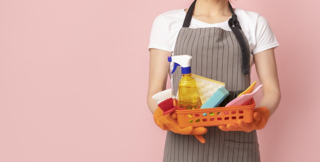 Professional Cleaning Services. Basket With Household Supplies In Hands Of Unrecognizable Housemaid